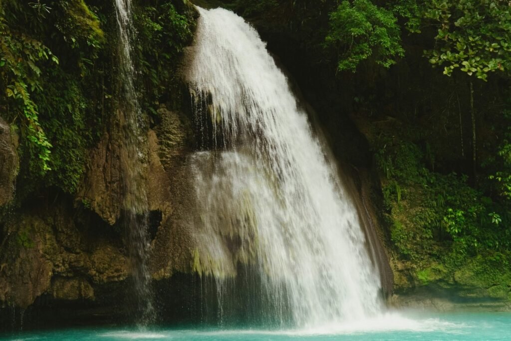 Kawasan Falls cascading into turquoise water surrounded by tropical forest in Badian, Cebu.