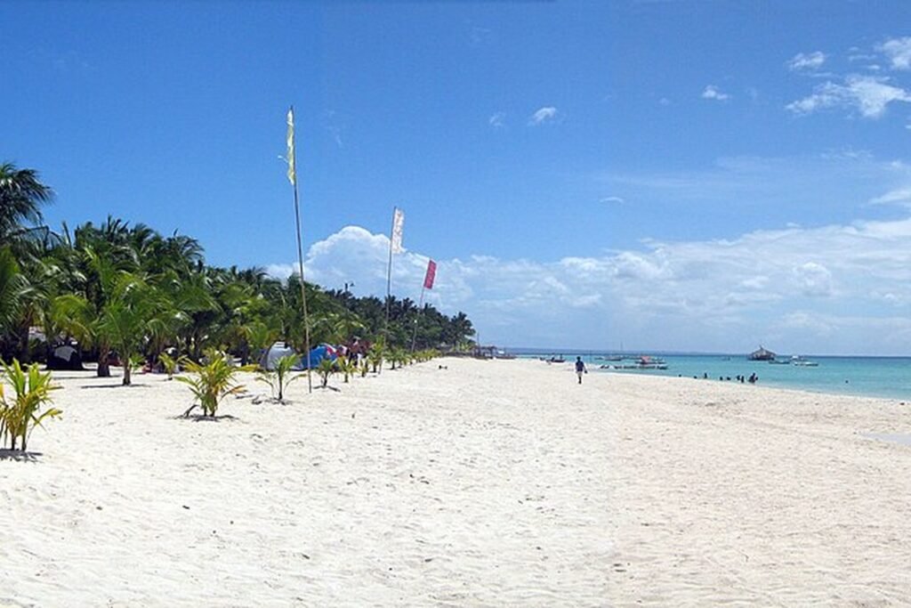 White sandy beach, coconut palms and turquoise sea at Sugar Beach on Bantayan Island, Cebu.