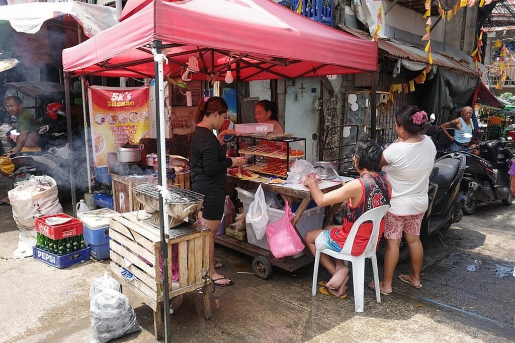 Street food vendors preparing and selling local dishes at Carbon Market in Cebu City.